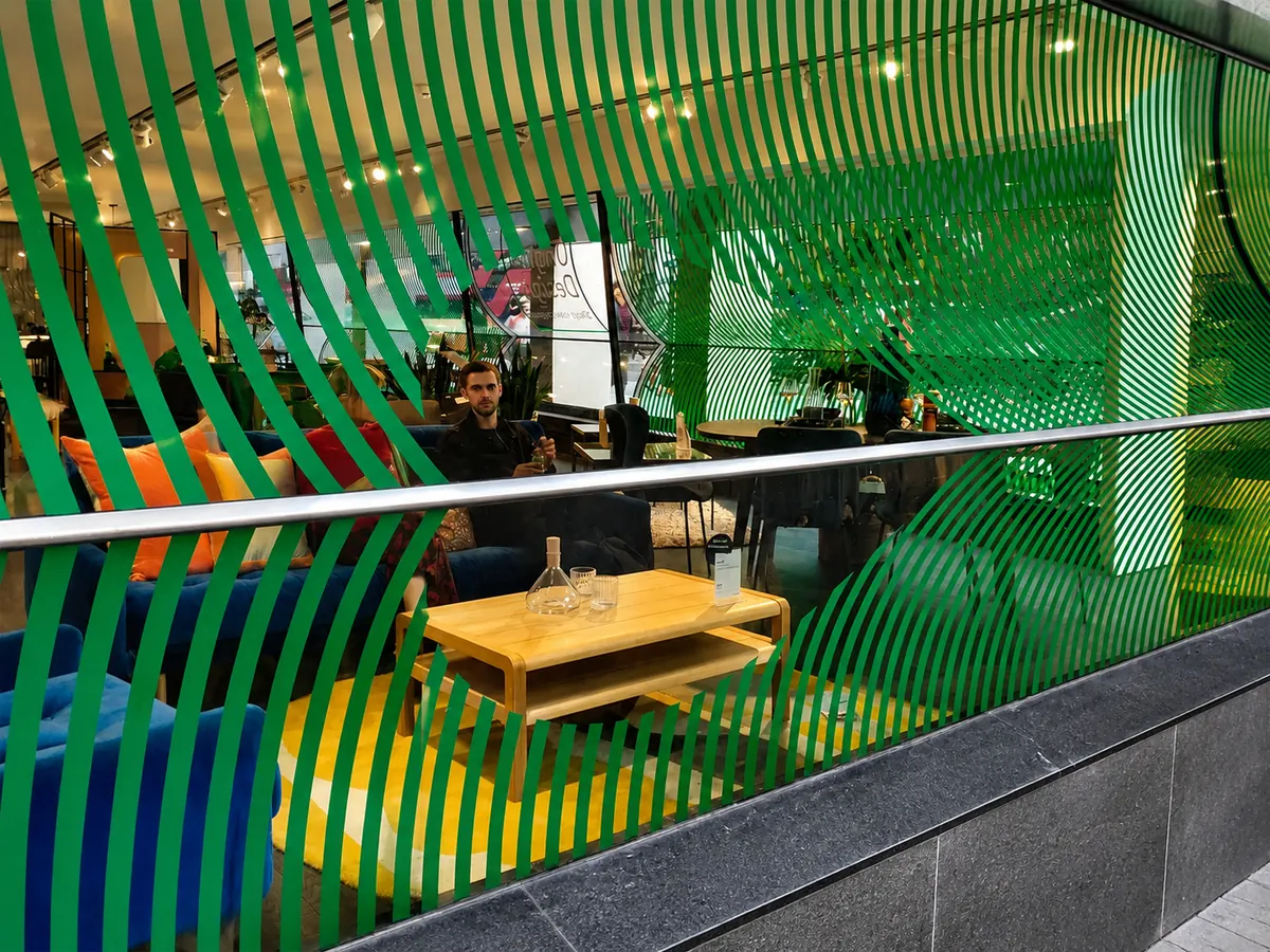 Green cut vinyl wave stripes applied across restaurant glazing for a hospitality fit-out in London