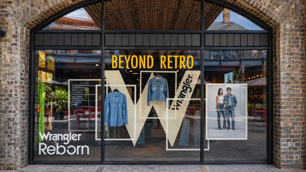 Large cut vinyl letters and layered window display graphics across a retail shop front