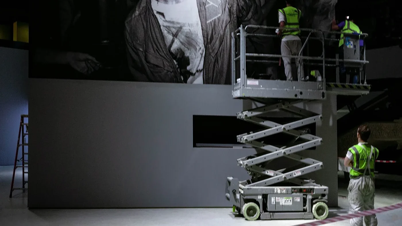 City Images fitters on a scissor lift installing a full-height gallery wall image in a London exhibition space