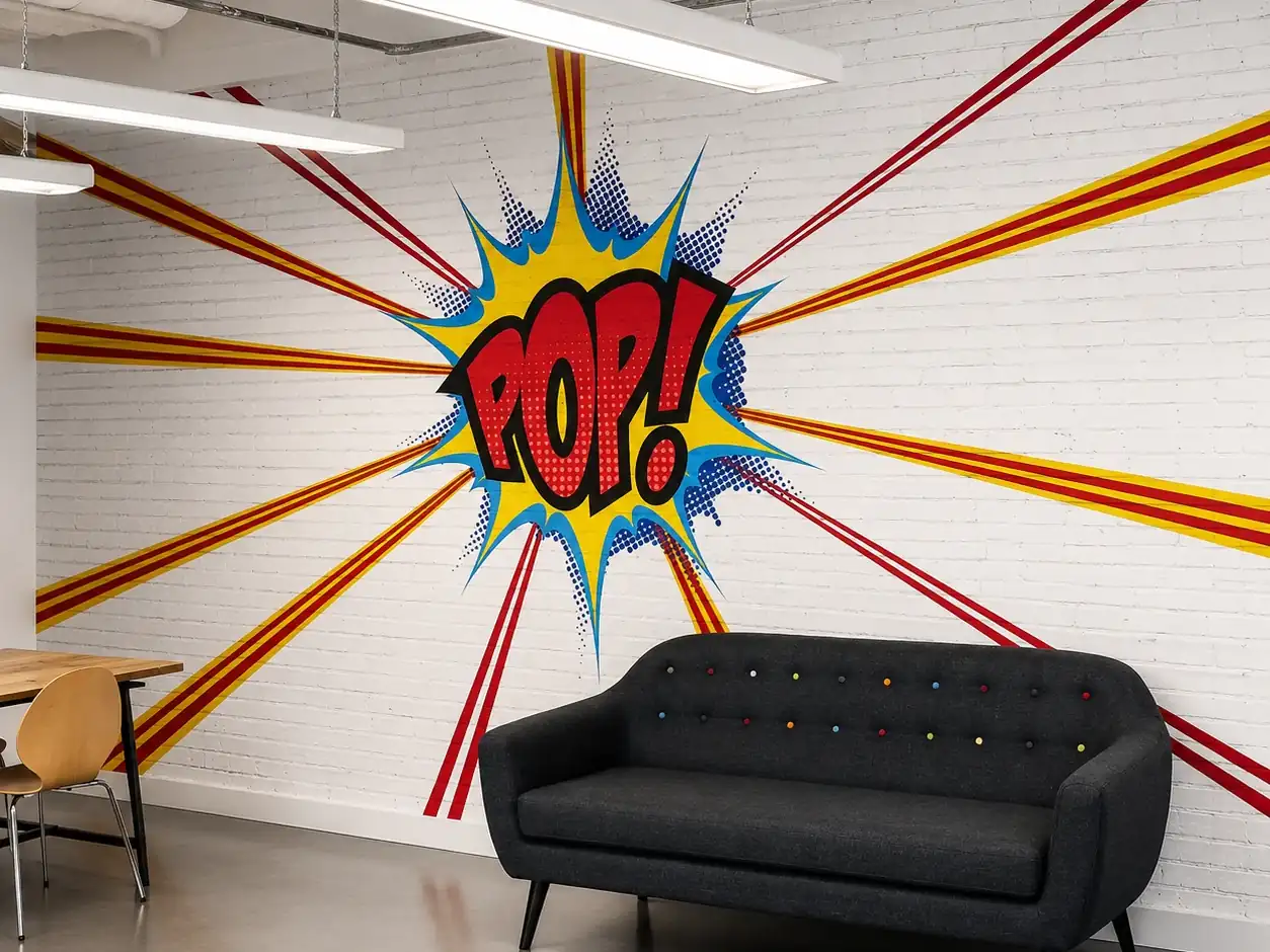 Printed pop-art wall mural installed across a white brick wall in an office breakout space