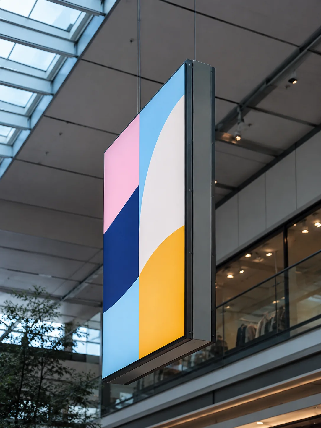 Double-sided suspended light box hung in a retail atrium for wayfinding